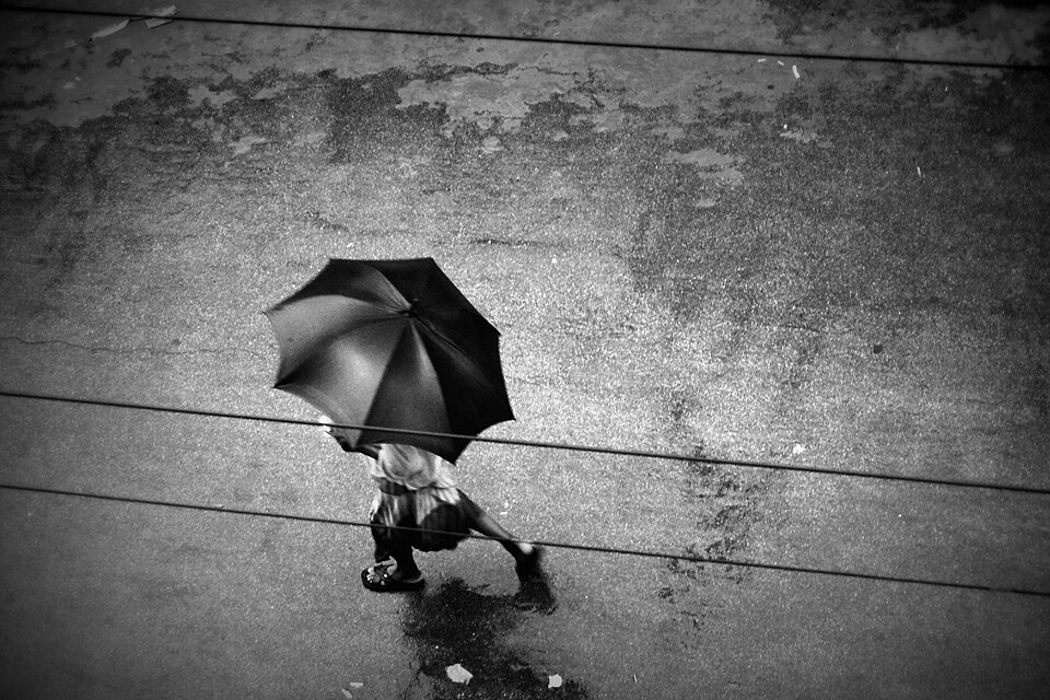 Una ragazza che passeggia sotto la pioggia con un ombrello